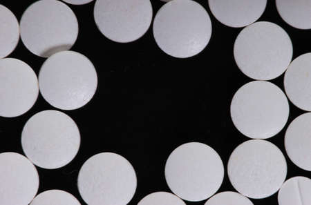 White pills on black background with copy space
