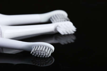 Three toothbrushes on a black reflective backgroundの写真素材