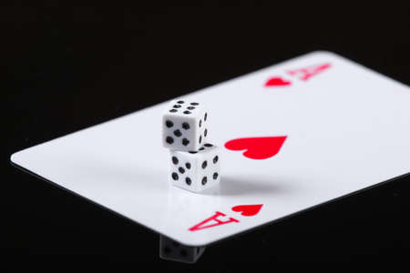 Ace of hearts with dice on a black background.の写真素材