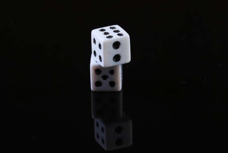 Two dice on a black background with reflection