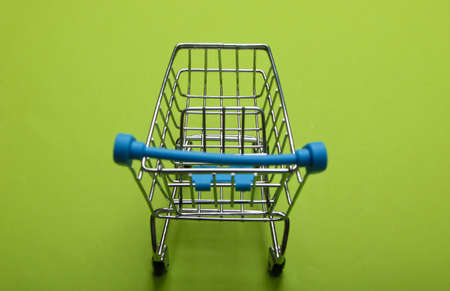 Mini supermarket trolley on green background. Shopping conceptの写真素材