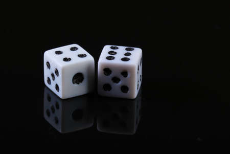Two dice on a black background with reflectionの写真素材