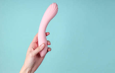 hand holding Sex toy for women on blue background.の写真素材