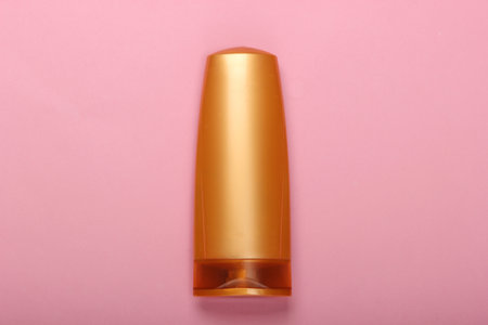 Shampoo bottle on pink pastel background. Hair care. Hygiene and cosmetics. Beauty flat lay. Top...
