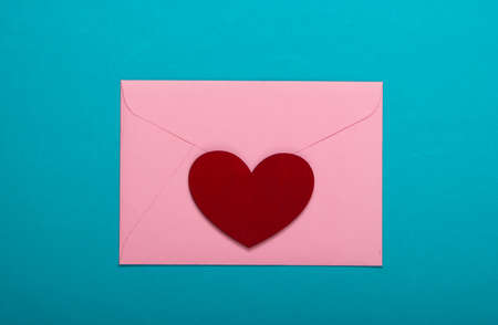 Envelope with red heart (valentines) on blue background. Valentine's Day. Top view