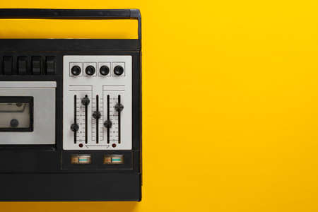 Retro audio tape recorder. Retro media on yellow background. Top view. Copy spaceの写真素材