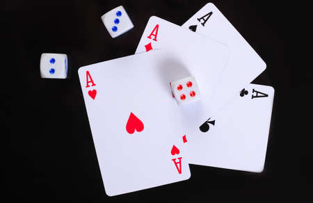 Dice with four aces on a black background.