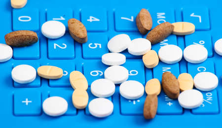 Pills on blue calculator button close-upの写真素材