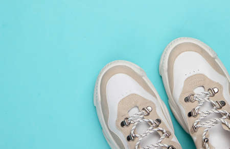 Fashionable sneakers on a blue background. Top view. Minimalismの写真素材