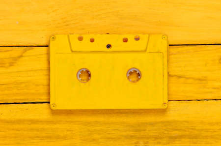Retro audio cassette on a yellow wooden background. 80s. top viewの写真素材