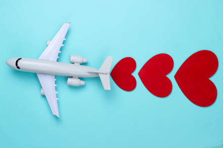 Air travel lover. Airplane figurine with red hearts on blue background. top viewの写真素材