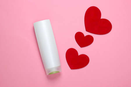 Shampoo bottle with hearts on a pink pastel background. beauty care. top view. minimalismの写真素材