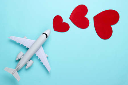 Air travel lover. Airplane figurine with red hearts on blue background. top viewの写真素材