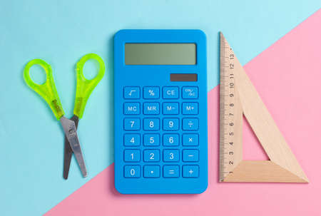 Stationery (school) scissors, calculator, triangle ruler on pink blue pastel background. School and office supplies. top view. minimalismの写真素材