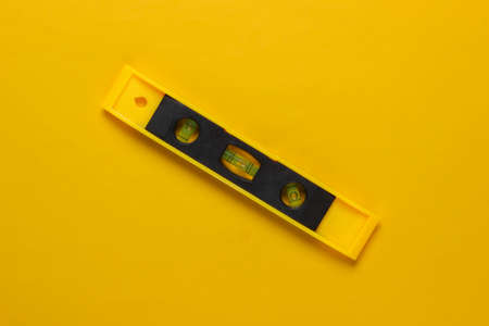 Construction level on a yellow studio background. top view. minimalismの写真素材