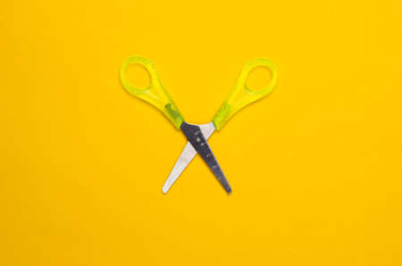 Stationery (school) scissors on a yellow background. top view. minimalism