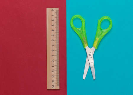 Stationery (school) scissors, ruler on red blue background. school supplies. top view. minimalism