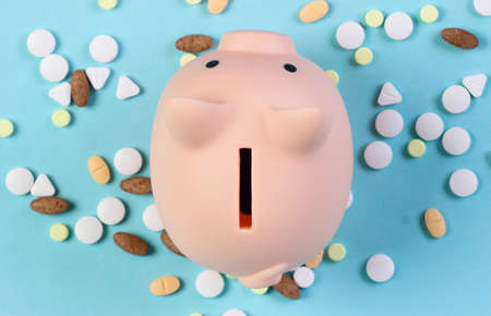 Piggy bank with pills on blue background. top viewの写真素材