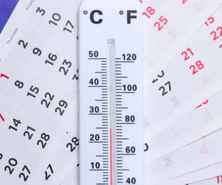 Weather thermometer on monthly calendar close up