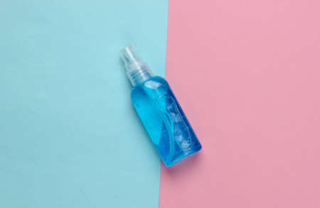 Antiseptic bottle on a blue-pink background. Disinfectant. Top view