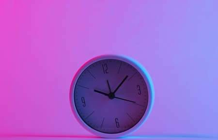 Clock in trendy neon light. Gradient pink-blue glow. Concept art. Minimalismの写真素材