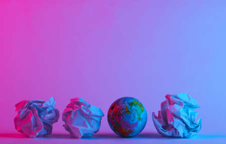 Globe with crumpled paper balls in trendy neon light. Gradient pink-blue glow. Concept art....