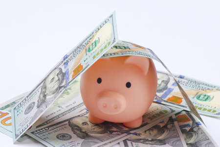 Piggy bank with hundred dollar bills closeup.の写真素材