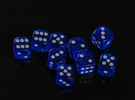 Blue dice on a black background. Game addiction. Luck