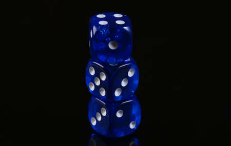 Blue dice on a black background. Game addiction. Luck