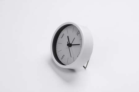 White clock on white background. Minimalistic studio shot.の写真素材