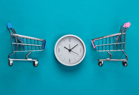 Shopping time. Supermarket trolleys with clock on blue background. Minimalism. Top view