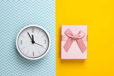 Christmas, New Year theme. Gift box with clock on yellow blue background. Top viewの写真素材