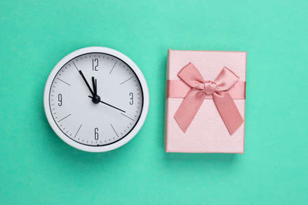 Christmas, New Year theme. Gift box with clock on mint green background. Top viewの写真素材