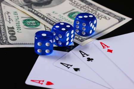 Four aces with dices and hundred dollar bills on a black background. Gamblingの写真素材