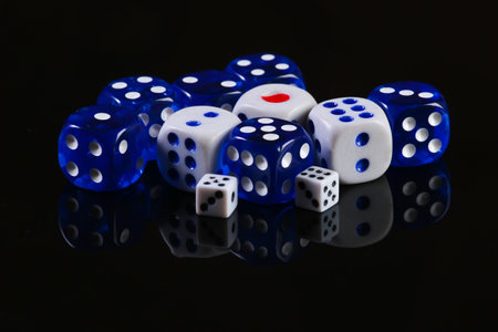 A lot of different dice on a black background with reflectionの写真素材