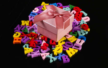 Gift box with colored letters on a black background