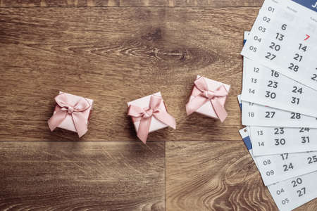 Gift boxes with a monthly calendar on wooden floor. Top Viewの写真素材