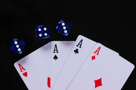 Four aces with dice on a black background.