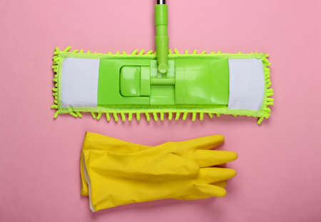 Plastic green mop, gloves on pink background. Disinfection and cleaning in the house. Top viewの写真素材