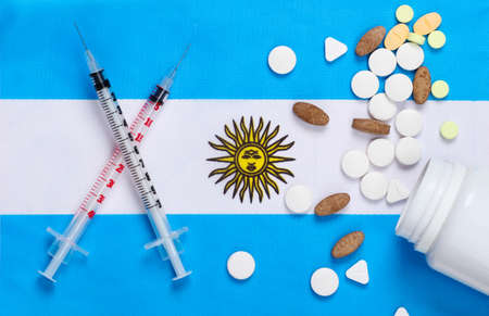 Syringes and pills with the flag of Argentina. Vaccination. Pandemic covid-19の写真素材