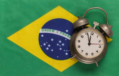 Vintage alarm clock on background of Brazil flagの写真素材