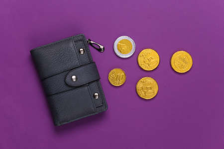 Leather wallet with coins on purple background. Top viewの写真素材