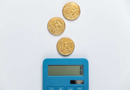 Calculator with coins on white background. Top viewの写真素材