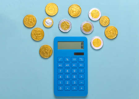 Calculator with coins on blue background. Top viewの写真素材