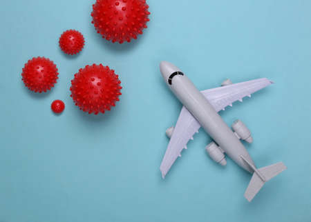 Toy airplane with virus strain models on a blue background.の写真素材