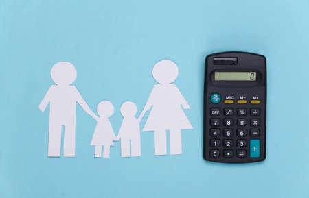 Paper happy family together with calculator on blue background. Calculation of family expenses, budgetの写真素材