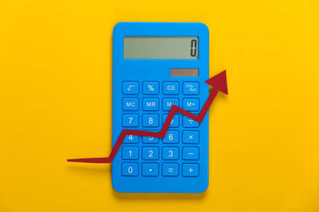 Calculator with red growth arrow on yellow background. Arrow graph going up. The economic growthの写真素材