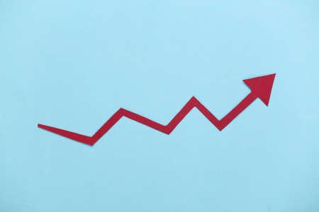 Red growth arrow on blue background. Arrow graph going up. The economic growthの写真素材