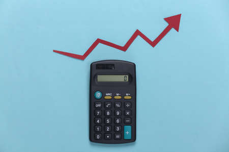 Calculator with red growth arrow on blue background. Arrow graph going up. The economic growthの写真素材