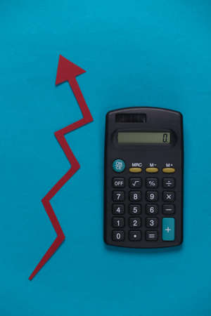 Calculator with red growth arrow on blue background. Arrow graph going up. The economic growthの写真素材